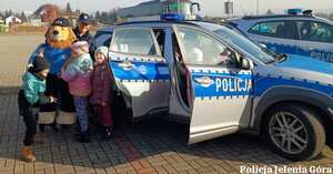 dzieci przy radiowozie z komisarzem lwem i policjantką