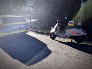 radiowóz i skuter na poboczu drogi