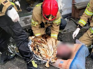 strażacy ratują osobę poszkodowaną w pożarze