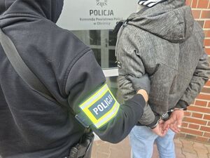 policjant prowadzi zatrzymanego