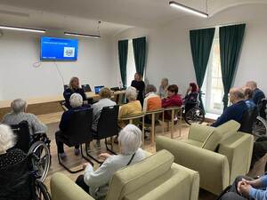 policjantki rozmawiają w sali z osobami starszymi