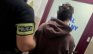 policjant prowadzi zatrzymanego