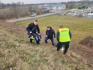 trzech policjantów wyciąga wciąga osobę poszukiwaną w kocu termo aktywnym na górę