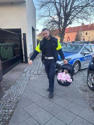 policjant nis acy małe dziecko w foteliku