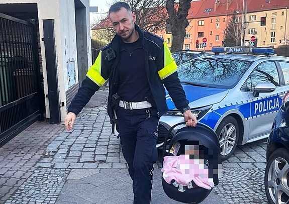 Policjant niosący dziecko w nosidełku