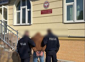 policjanci prowadzą zatrzymanego