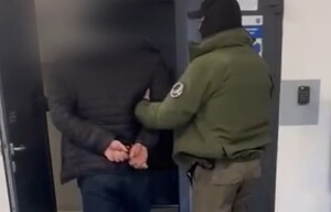 policjant prowadzi zatrzymanego