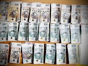 banknoty stu i dwustuzłotowe leżące na stole