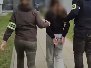 policjanci prowadzą zatrzymaną 13 latkę