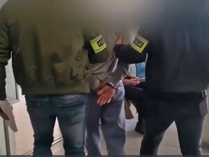 POLICJACI PROWADZĄ ZATRZYMANEGO