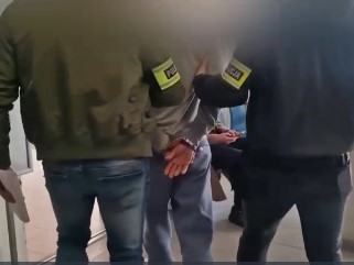 POLICJACI PROWADZĄ ZATRZYMANEGO