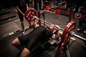 mężczyzna podnosi sztangę