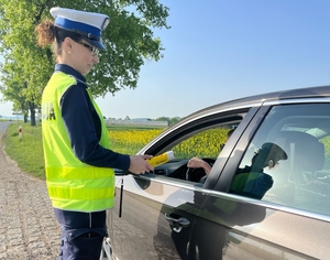 POLICJANT KONTROLUJE ALKOMATEM TRZEŹWOŚĆ KIEROWCÓW