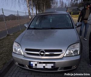 Zdjęcie przedstawia przód samochodu osobowego marki opel koloru szarego.