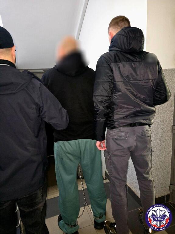 Policjanci prowadzą zatrzymanego