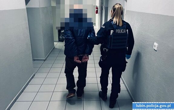 policjant prowadzi zatrzymanego