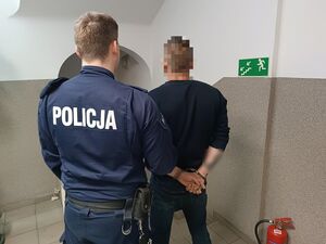 policjant prowadzi zatrzymanego