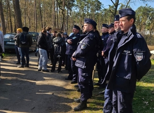 policjanci podczas akcji sadzenia lasu e mundurach przy sadzonkach