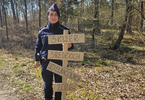 policjanci podczas akcji sadzenia lasu e mundurach przy sadzonkach