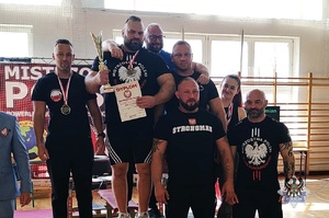 ludzie na podium z pucharami i medalami
