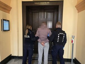 policjanci prowadzą zatrzymanego