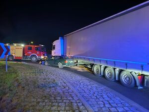 samochód osobowy po wypadku pod tirem obok wóz straży pożarnej