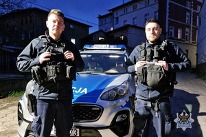 Umundurowani policjanci przy radiowozie