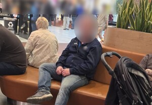 mężczyzna siedzący na ławce w centrum handlowym