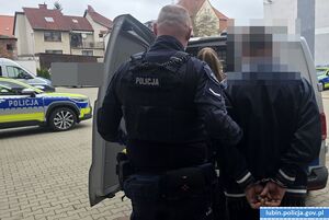Policjanci z zatrzymanym przy radiowozie