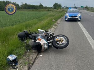 motor leżący na poboczu na drodze stoi radiowóz