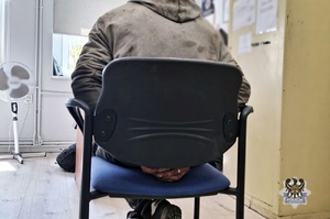 mężczyzna siedzący na krześle z rękoma z tyłu