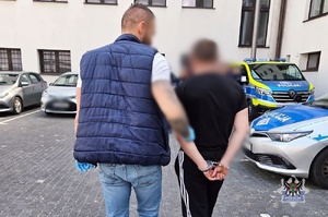policjant prowadzi zatrzymanego