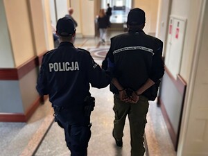 policjant prowadzi zatrzymanego
