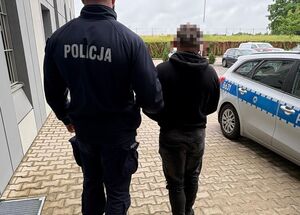 policjant prowadzi zatrzymanego