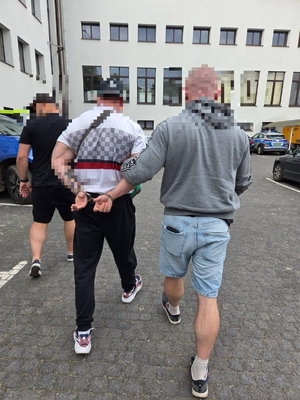 policjanci prowadzą zatrzymanego