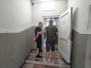 policjanci prowadzą zatrzymanego