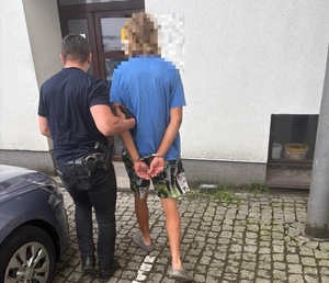 policjanci prowadzą zatrzymanego