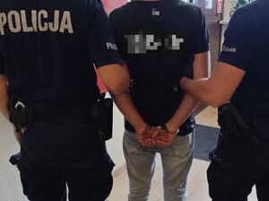 dwaj policjanci prowadzą zatrzymanego