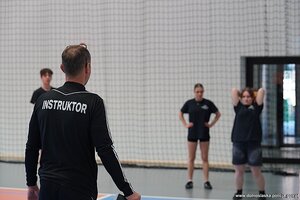 instruktor obserwuje jak kobieta rzuca piłką lekarską