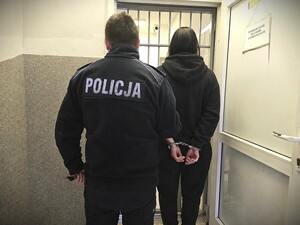policjant prowadzi zatrzymana kobietę