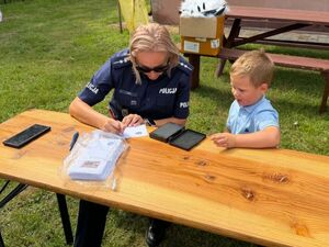 Policjanci rozmawiają z dziećmi na festynie