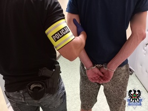 policjant prowadzi zatrzymanego