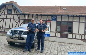 policjant i policjantka przy radiowozie