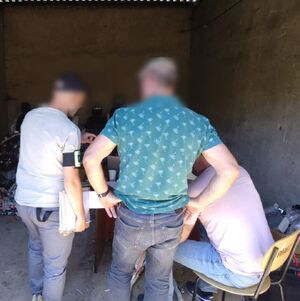 policjanci w cywilu przeszukują dziuplę samochodową