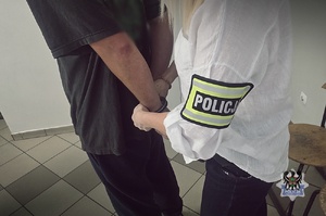 policjant prowadzi zatrzymanego
