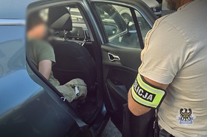 policjant prowadzi zatrzymanego