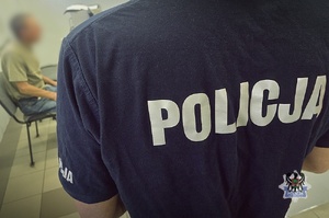 policjant prowadzi zatrzymanego