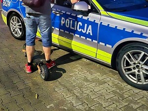 mężczyzna z hulajnogą przy radiowozie