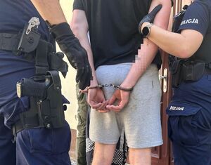 policjanci prowadzą zatrzymanego