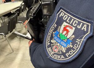 dwaj policjanci prowadzą zatrzymanego